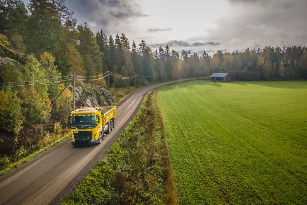 Camion sur une route de campagne entourée de forêts et de champs